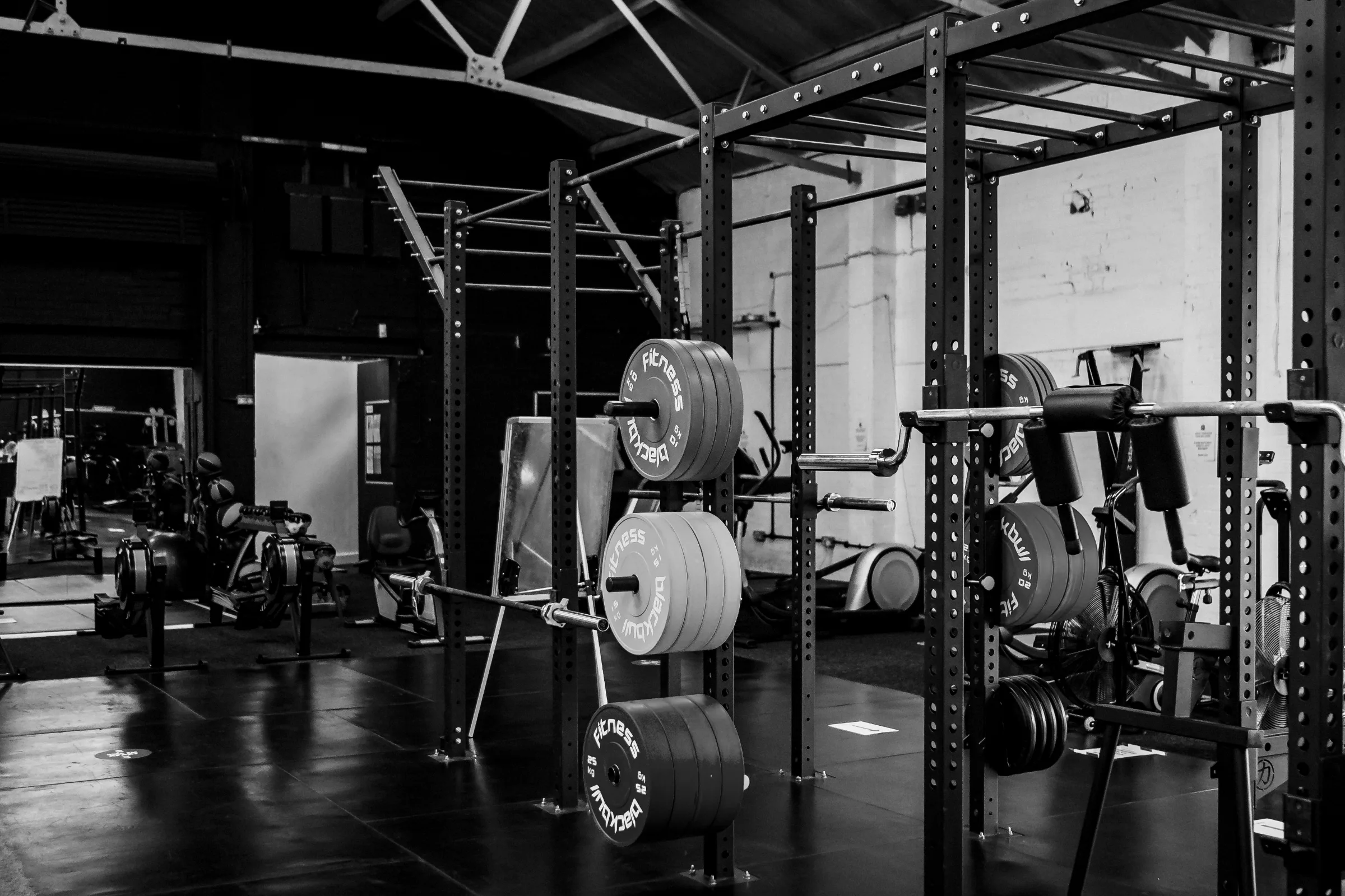 A squat rack loaded with bumper plates in an empty strength gym.